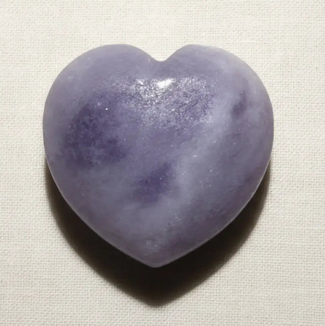 Close up lepidolite carved heart showing the mica inclusions. beautiful lavender color