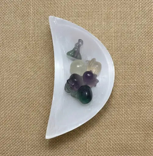 Close up photo Selenite Half Moon Bowl with fluroite mini halloween carvings