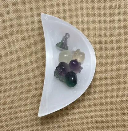Close up photo Selenite Half Moon Bowl with fluroite mini halloween carvings