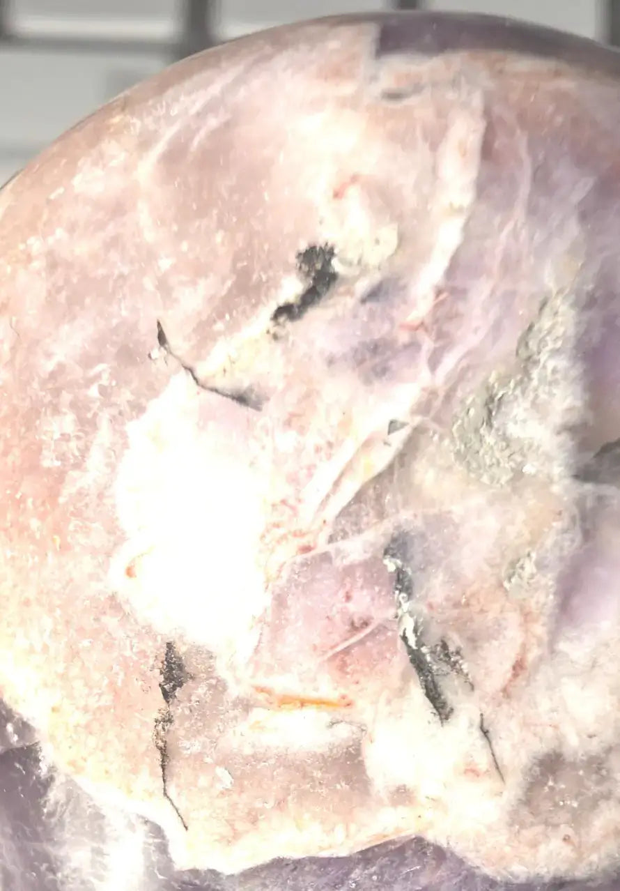 magnified photo amethyst sphere showing natural rultile and iron rich inclusions