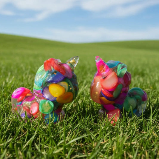 Two “skittle” unicorns resin figurines filled with dyed agate or stones and metal shavings organite like  