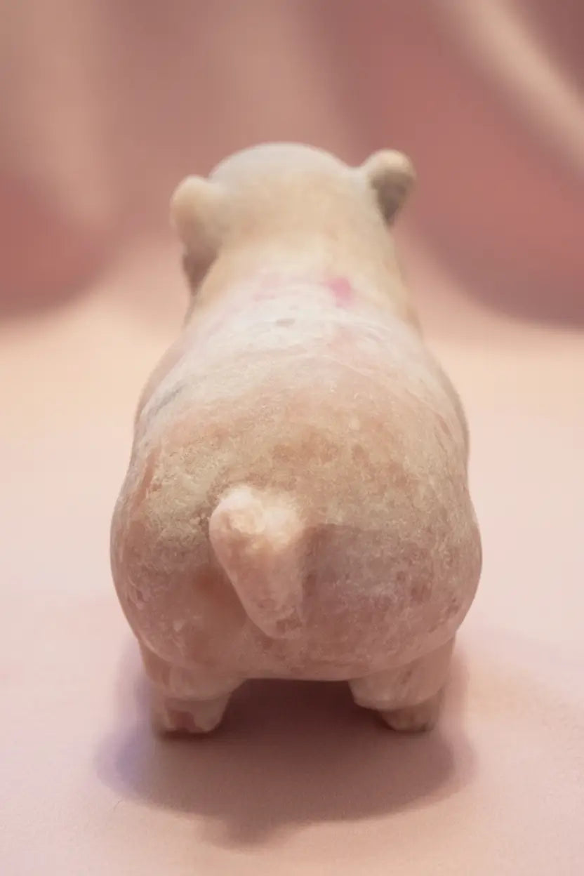Cute rear view of pink calcite carved pig showing the beautiful pink and off white 