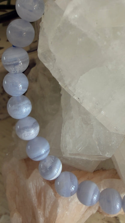 Blue agate beaded bracelet on a white stone surface