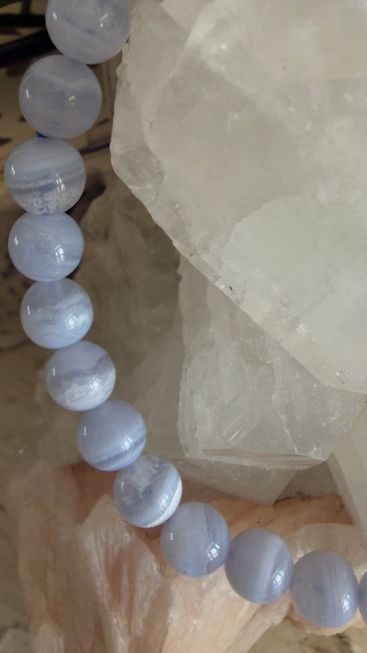 Blue agate beaded bracelet on a white stone surface