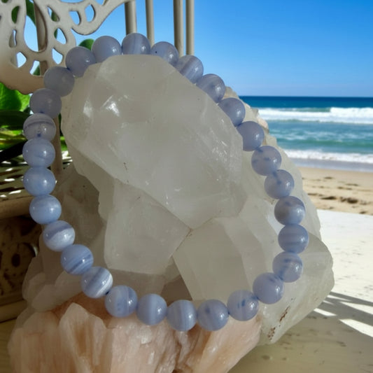Blue Lace Agate 7 mm Bead Bracelet on a beach setting with ocean in the background