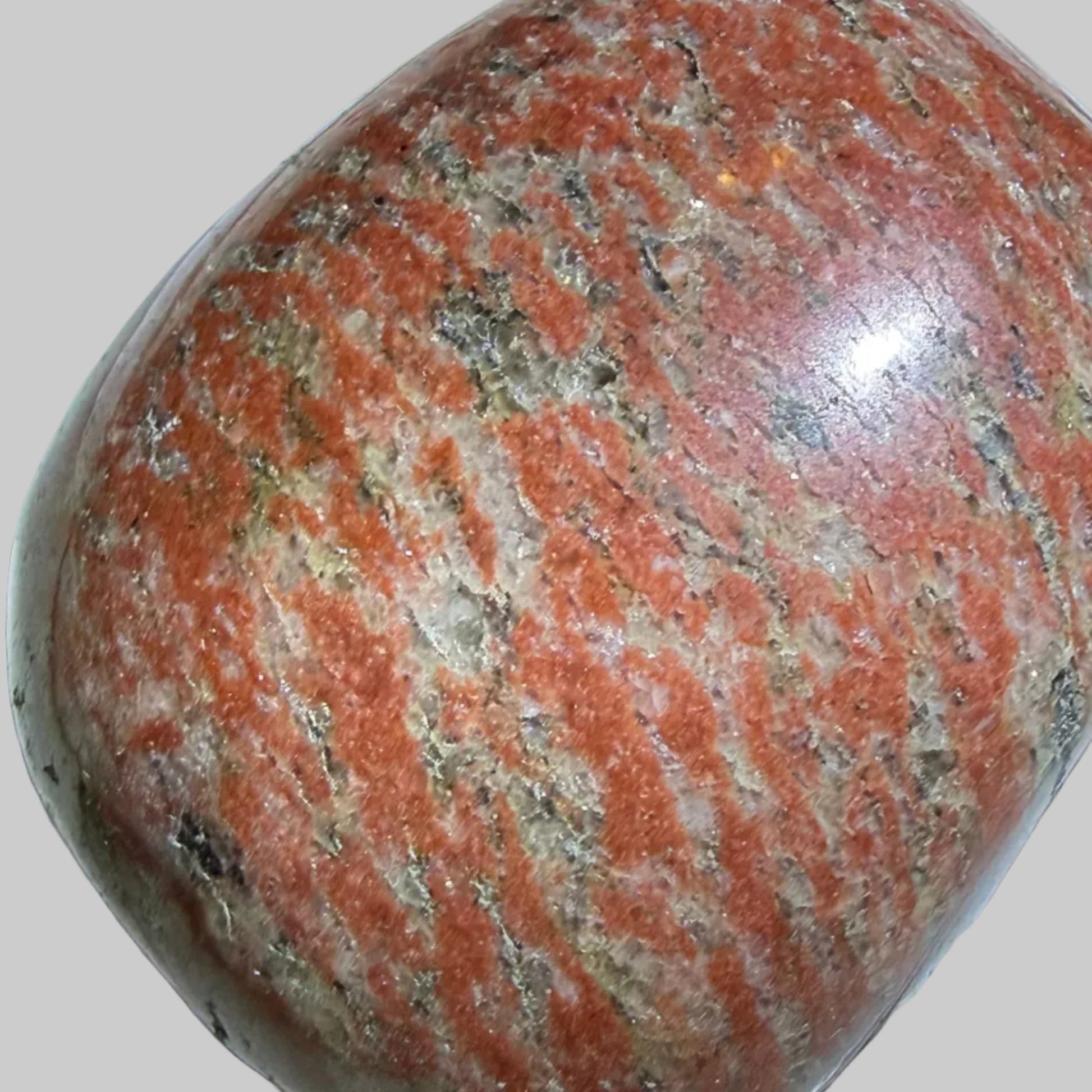 A polished reddish-brown stone with natural speckled patterns