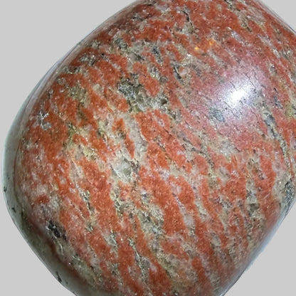 A polished reddish-brown stone with natural speckled patterns