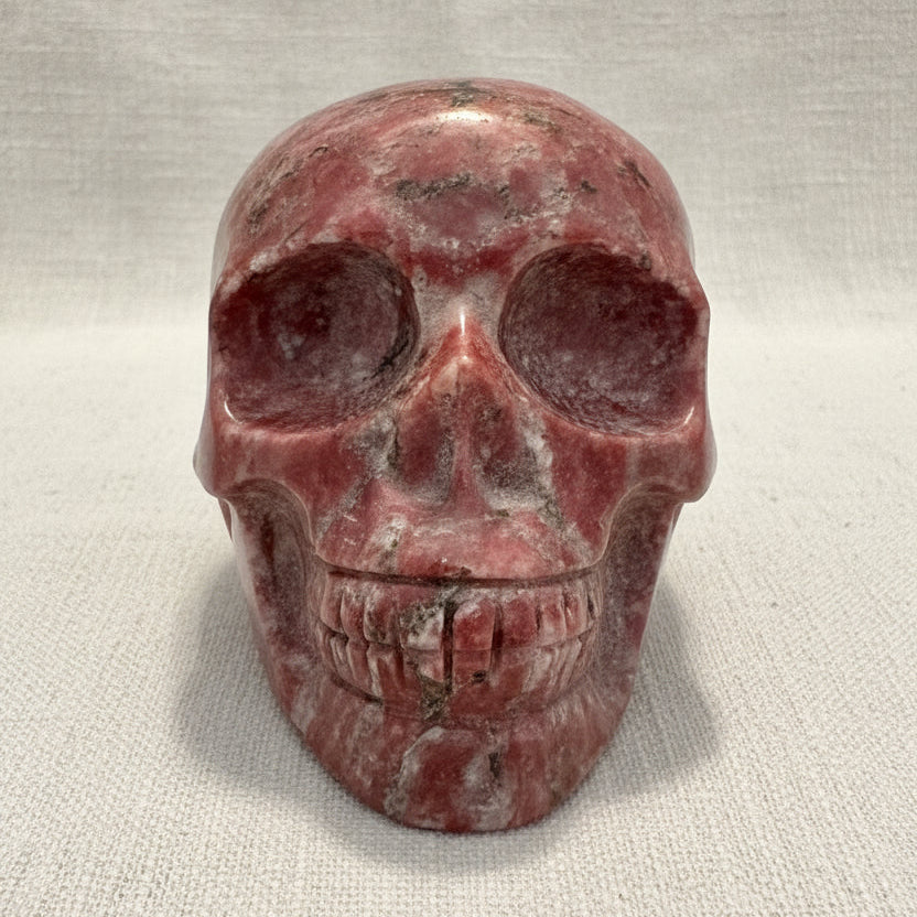 A carved red jasper crystal skull sculpture