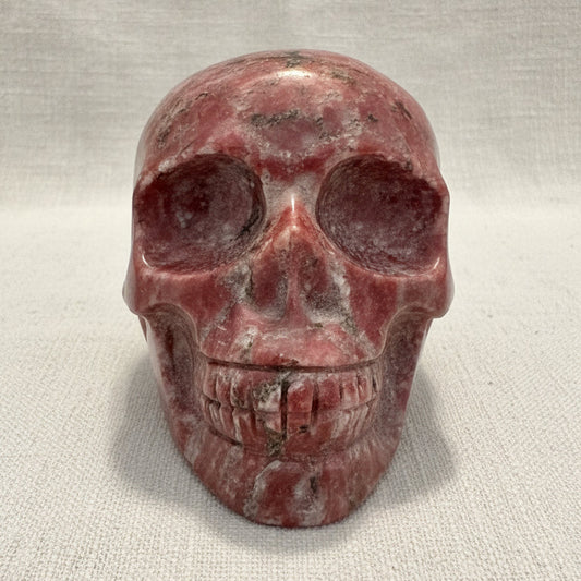 A carved red jasper crystal skull sculpture