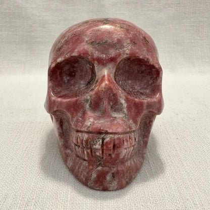 A carved red jasper crystal skull sculpture