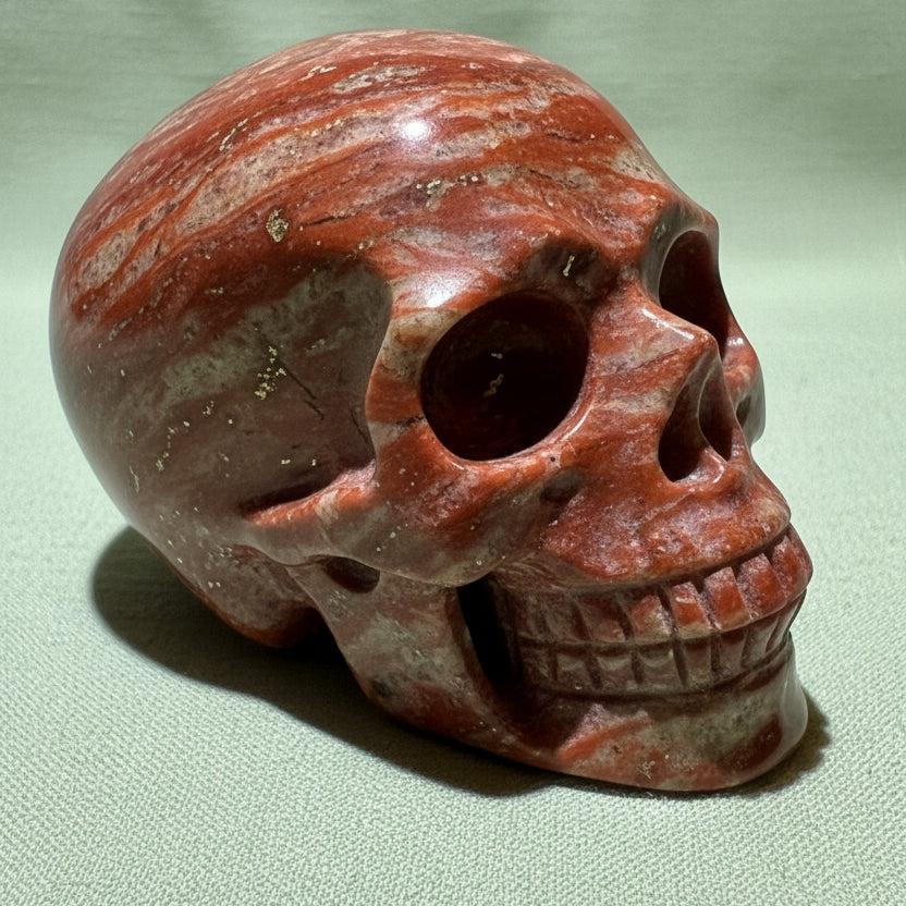 Warm orange and copper colors brecciated jasper hand carved skull traces of hematite and iron oxide 