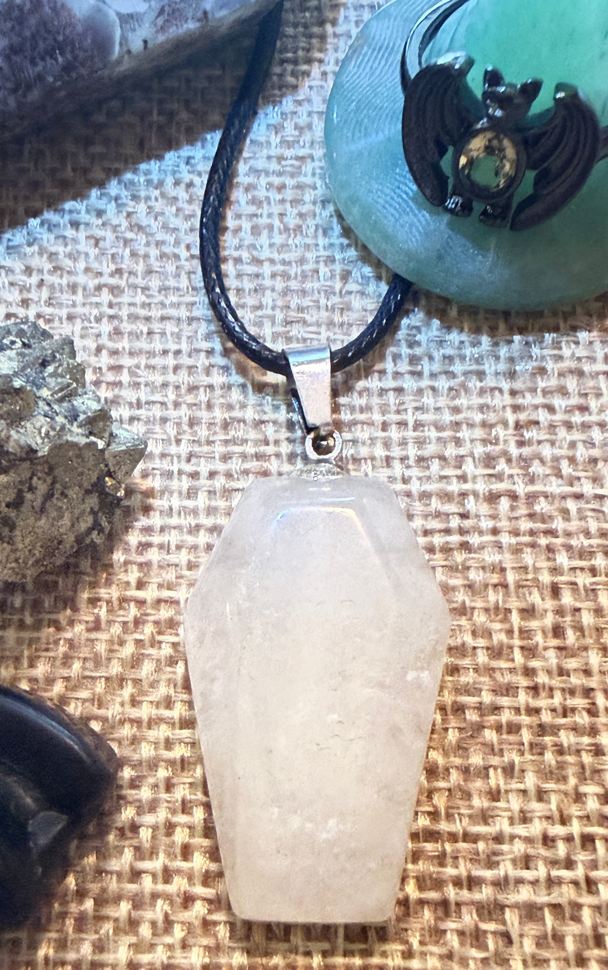 front view photo of clear quartz coffin shaped pendant and alloy citrine bat ring