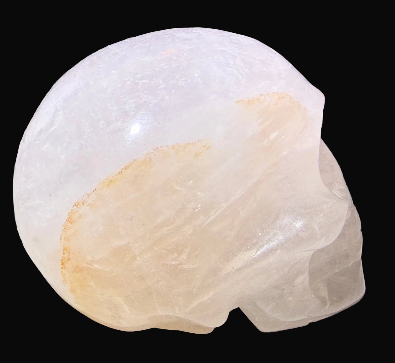 close up side view clear quartz skull with golden healer inclusions 