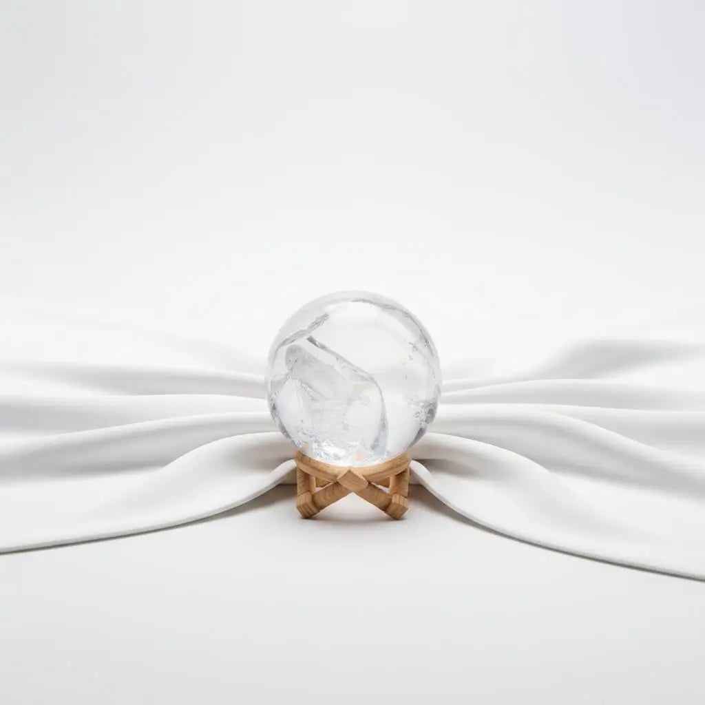 A clear quartz crystal sphere with a Y-shaped internal fissure, rainbow 