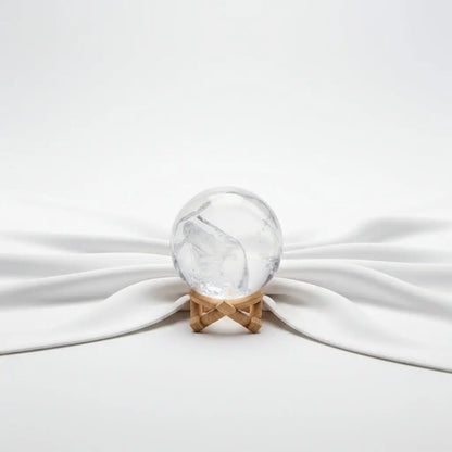 A clear quartz crystal sphere with a Y-shaped internal fissure, rainbow 