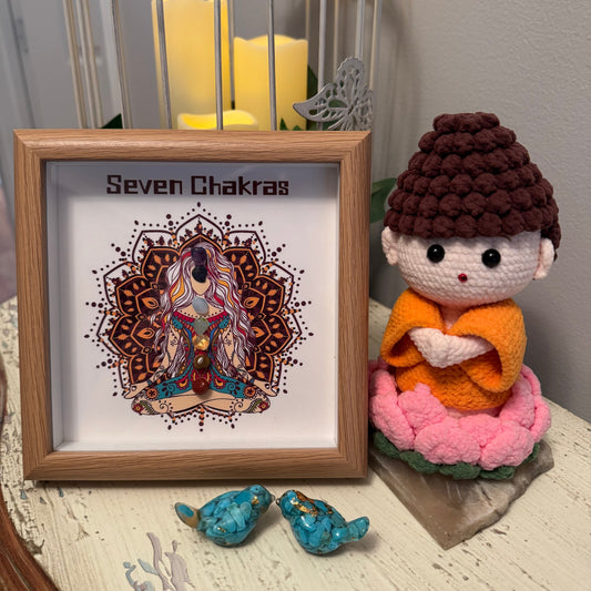 Framed "Seven Chakras" art, crocheted figure in lotus position, turquoise birds, birdcage with candles.