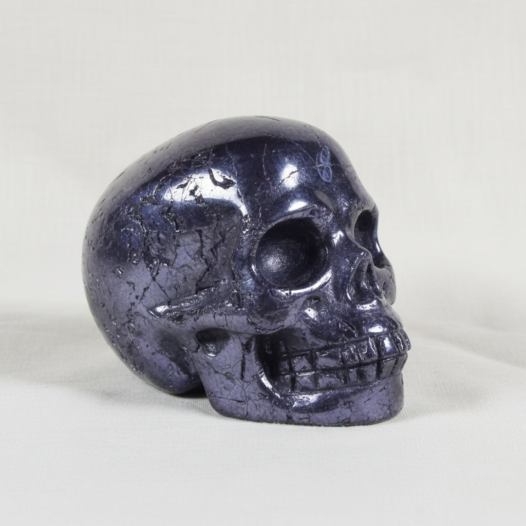 close up of beautiful silver hematite mini skull showing polished surfaces and raw natural surfaces