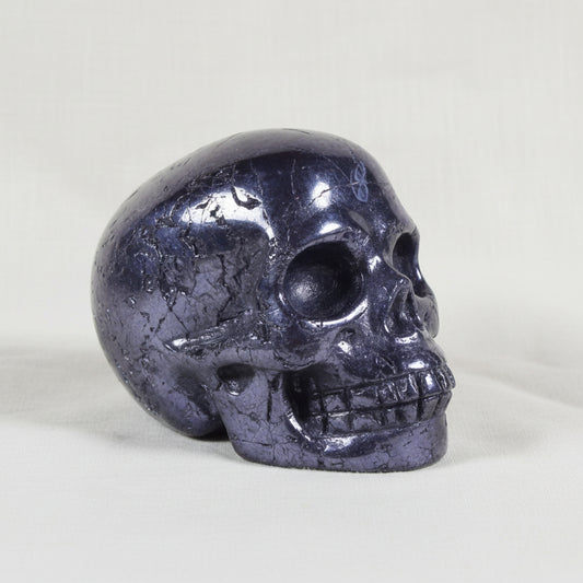 close up of beautiful silver hematite mini skull showing polished surfaces and raw natural surfaces