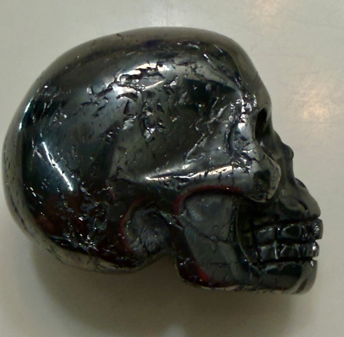 side view close up hematite skull shiny polished with natural unpolished for added dimension 