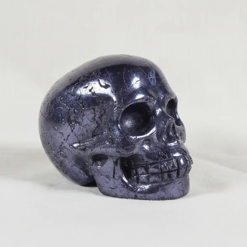 close up of beautiful silver hematite mini skull showing polished surfaces and raw natural surfaces