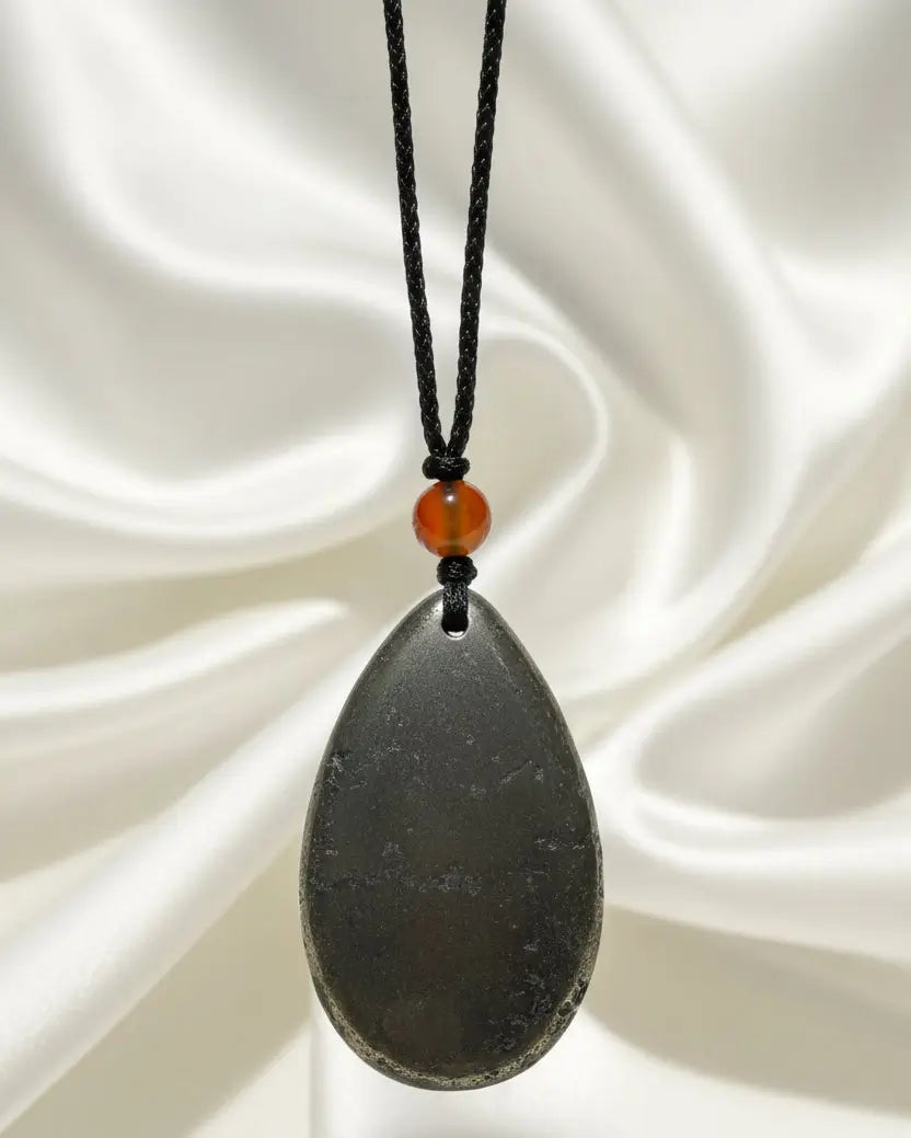 A teardrop-shaped hematite pendant on an adjustable cord with carnelian bead 8 mm