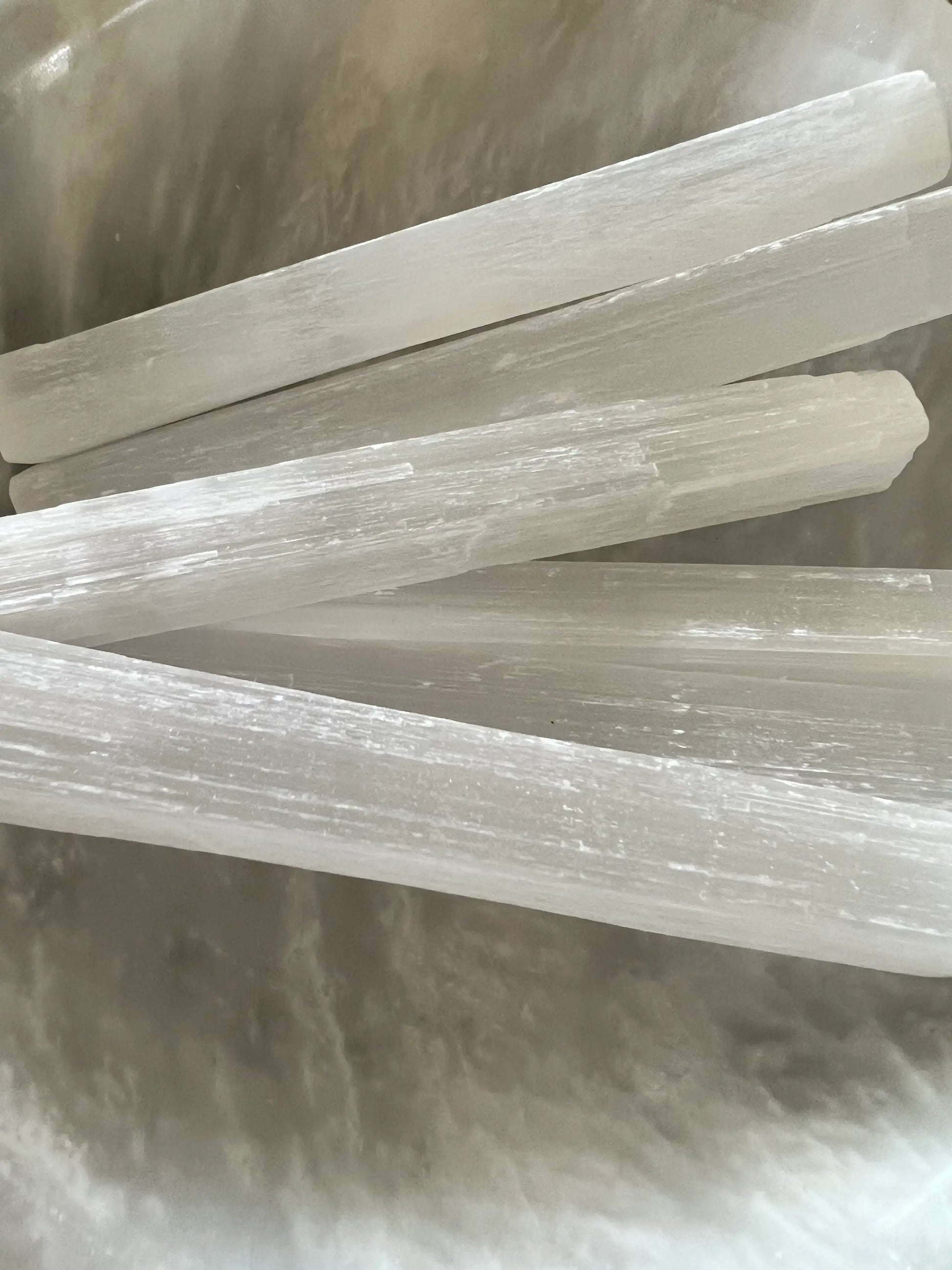 A close-up of a group of translucent selenite sticks.