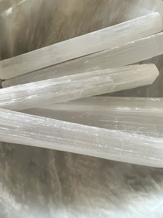 A close-up of a group of translucent selenite sticks.