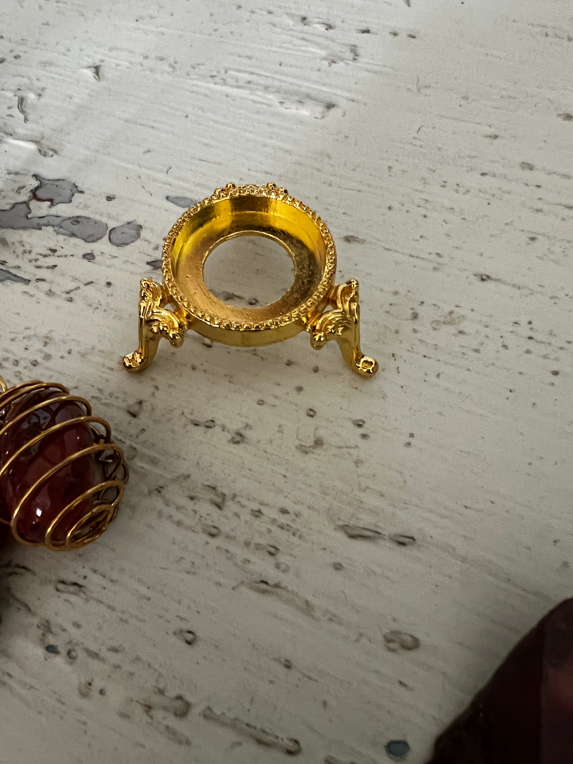 Gold pedestal and crystal-wrapped gem.