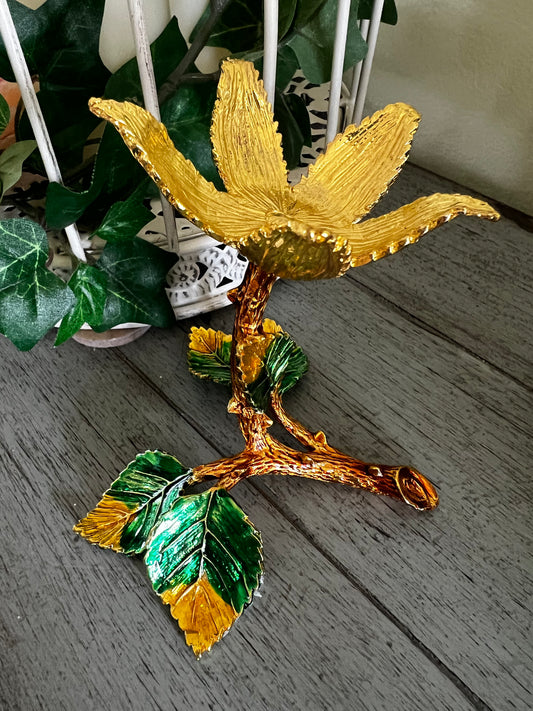 Gold Tone Flower Sphere Display Stand sitting on a table 
