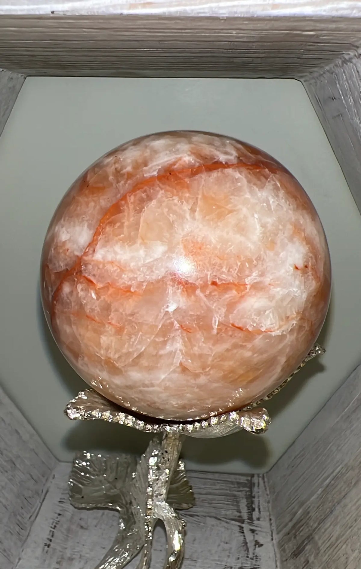 Large Orange Calcite sphere on silver floral stand