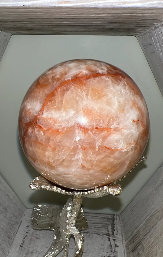 Large Orange Calcite sphere on silver floral stand