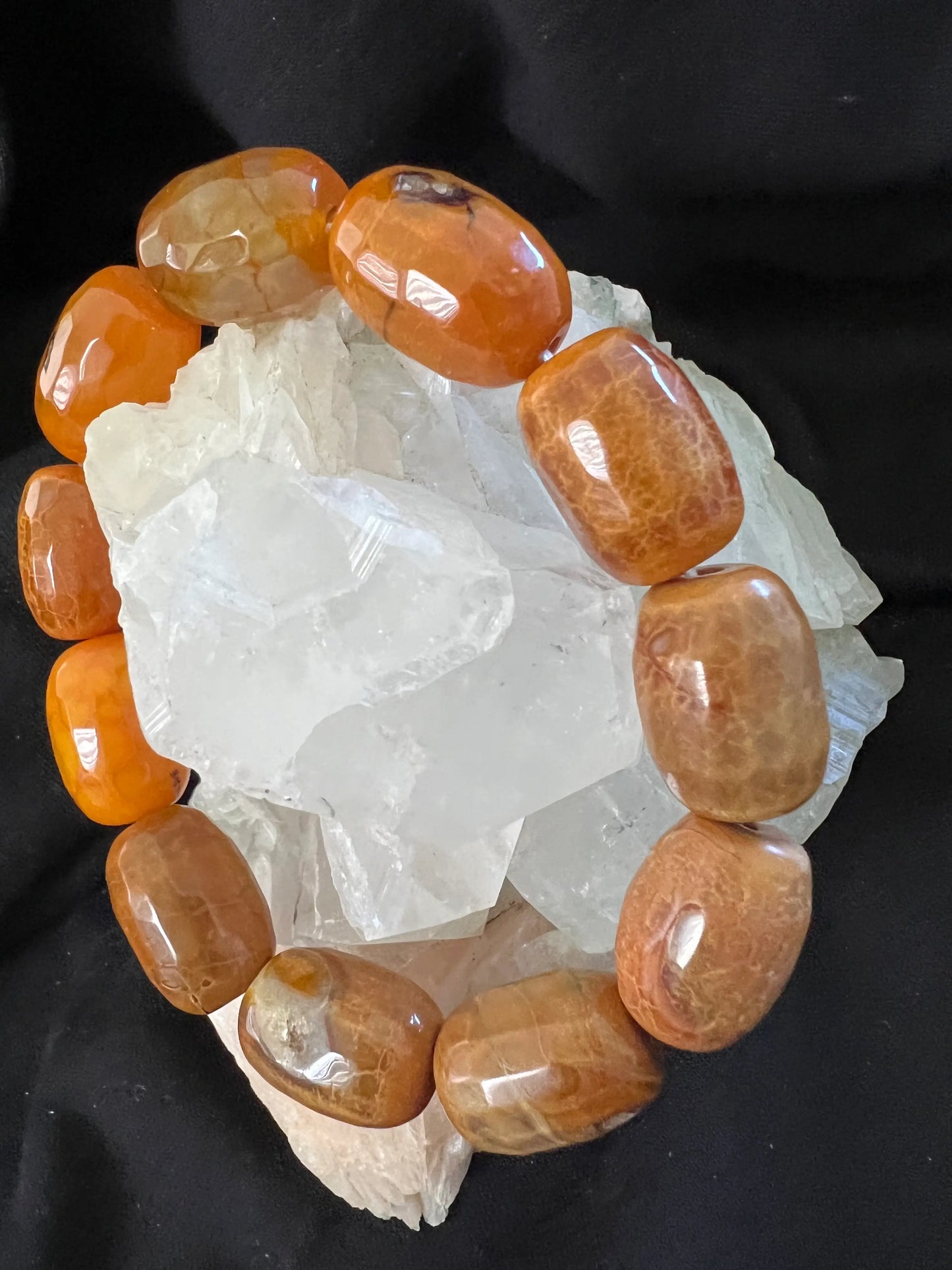 Snake Skin Agate orange beads arranged on white crystals