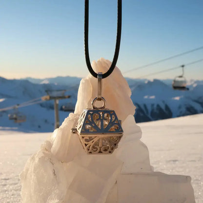 A necklace with a gold pendant on a white crystal.