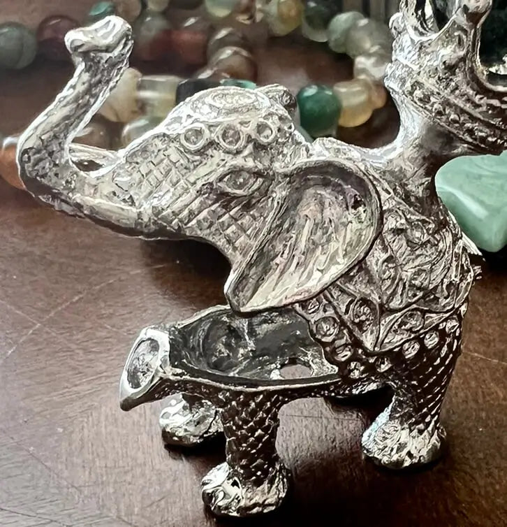 Silver elephant figurine with decorative details.
