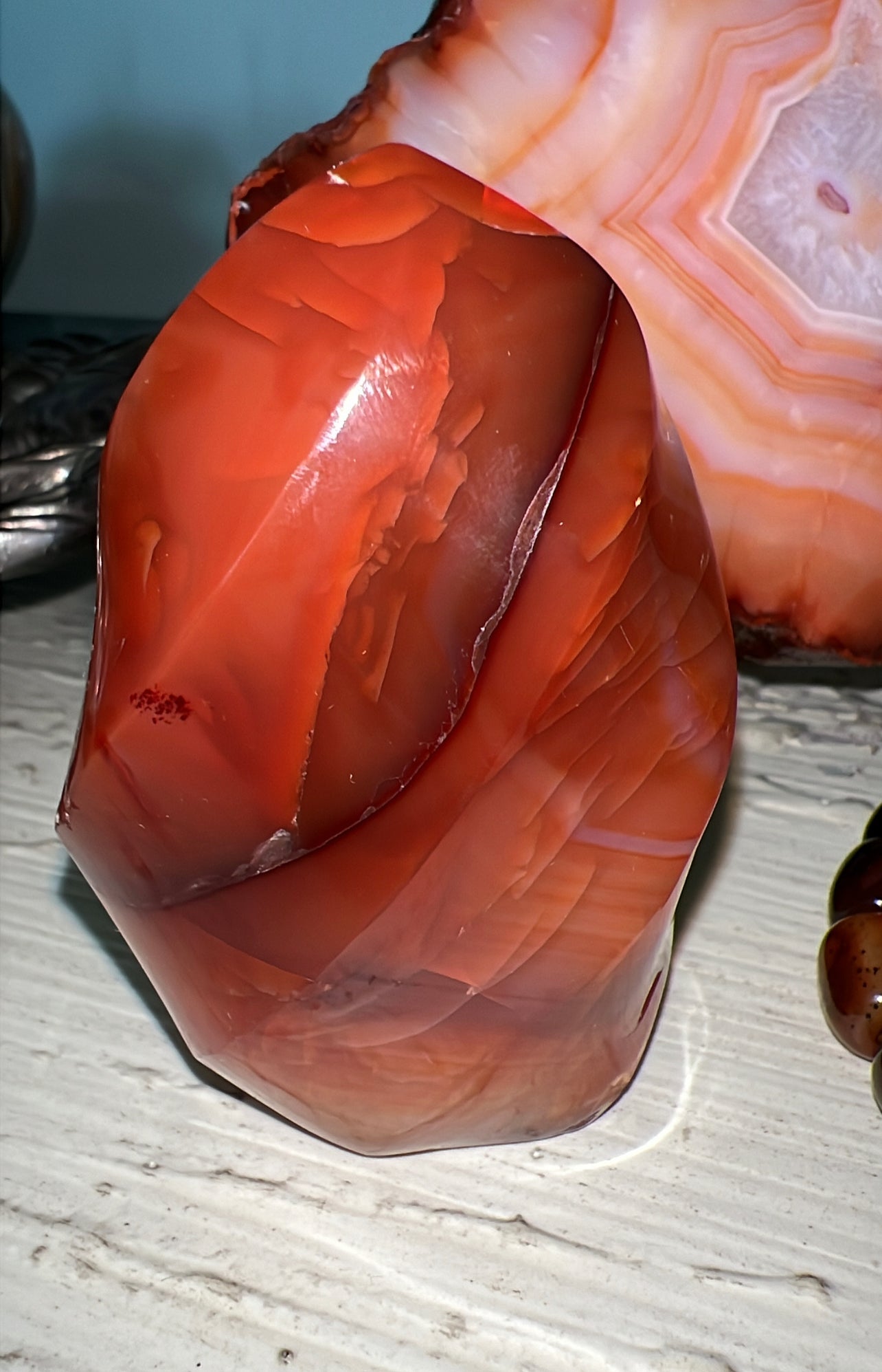 Polished red carnelian stone with layered patterns.
