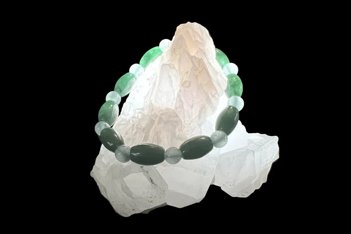 A beaded bracelet is draped over several white crystals.