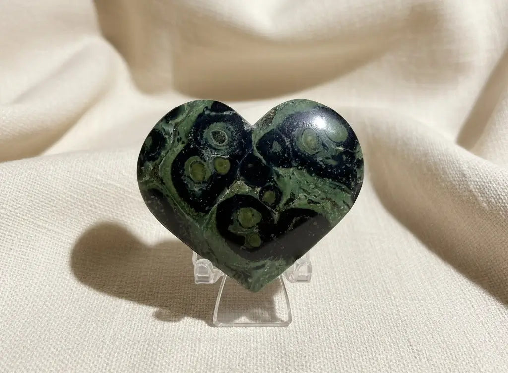 beautiful close-up of a carved heart  material is kambaba jasper light greens dark greens, and black swirls throughout