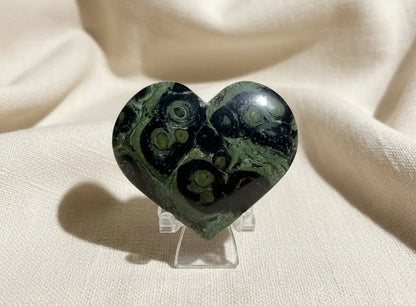 beautiful close-up of a carved heart  material is kambaba jasper light greens dark greens, and black swirls throughout