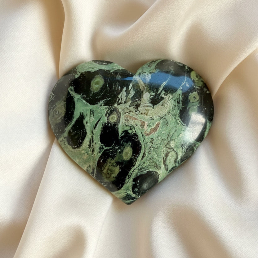 beautiful close up of a kambaba jasper carved heart green hues lime to dark green  black swirls 