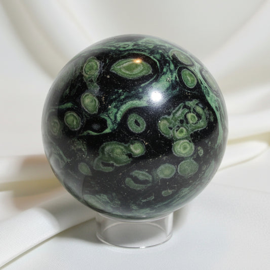 Close -up of kambaba jasper sphere kambaba has green hues from dark to lime green with black swirls through out 