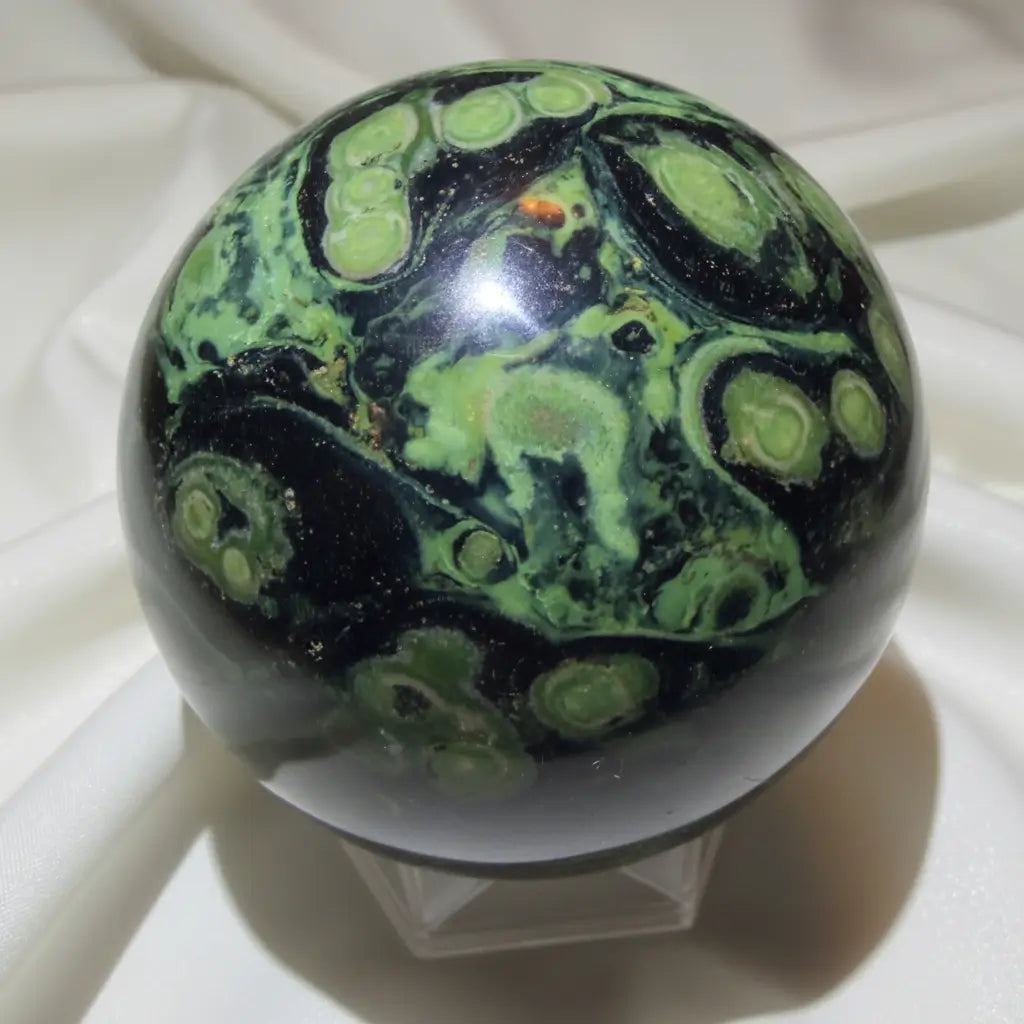 close up of kambaba jasper sphere bright green lime green to dark green colors with black swirls throughout 