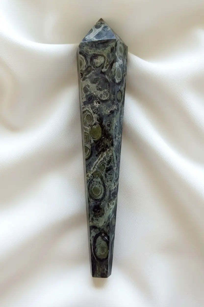 side view of a kambaba jasper wand beautiful hues of greens and back swirls throughout 
