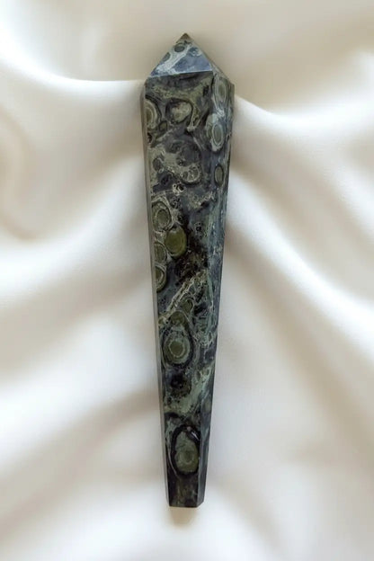 side view of a kambaba jasper wand beautiful hues of greens and back swirls throughout 