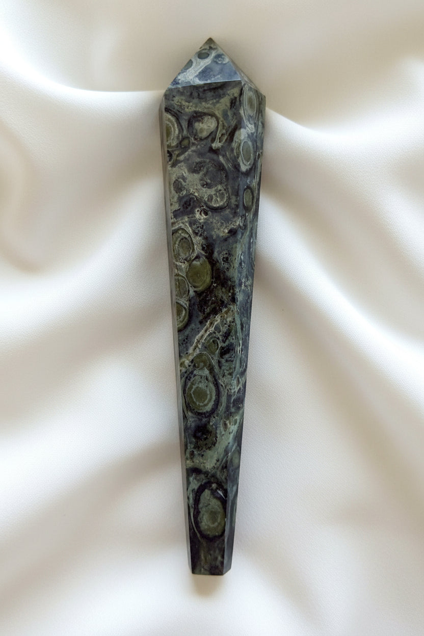 side view of a kambaba jasper wand beautiful hues of greens and back swirls throughout 