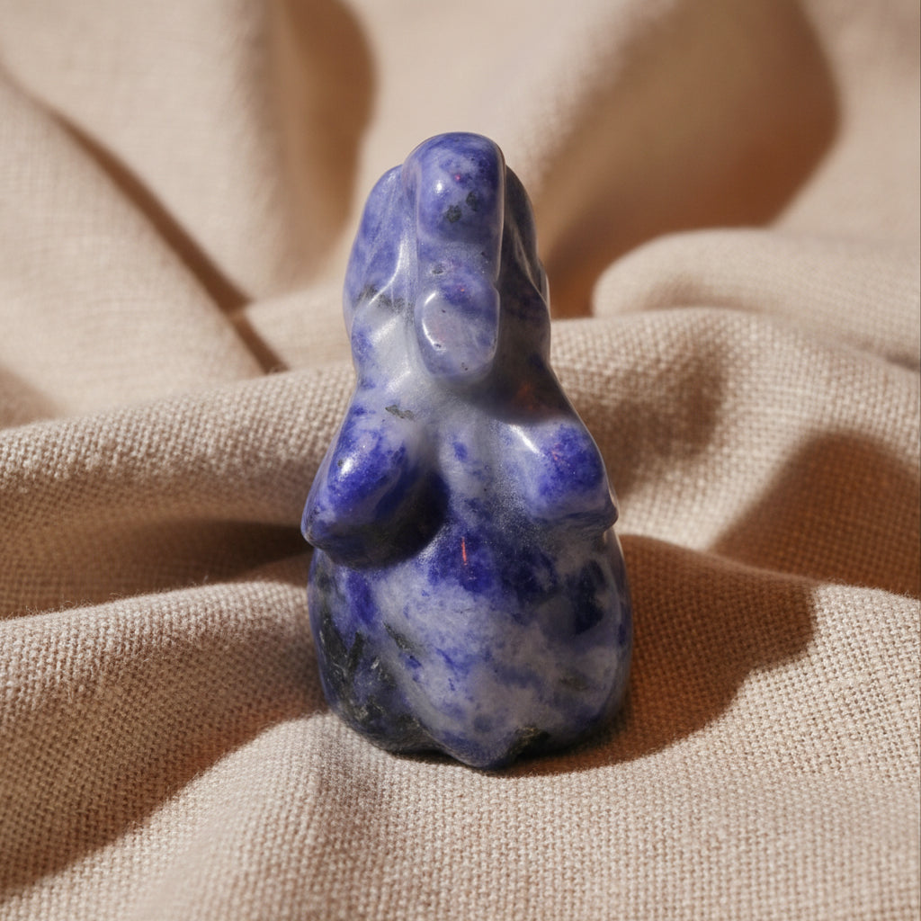 A polished lapis lazuli carving of an elephant looking down