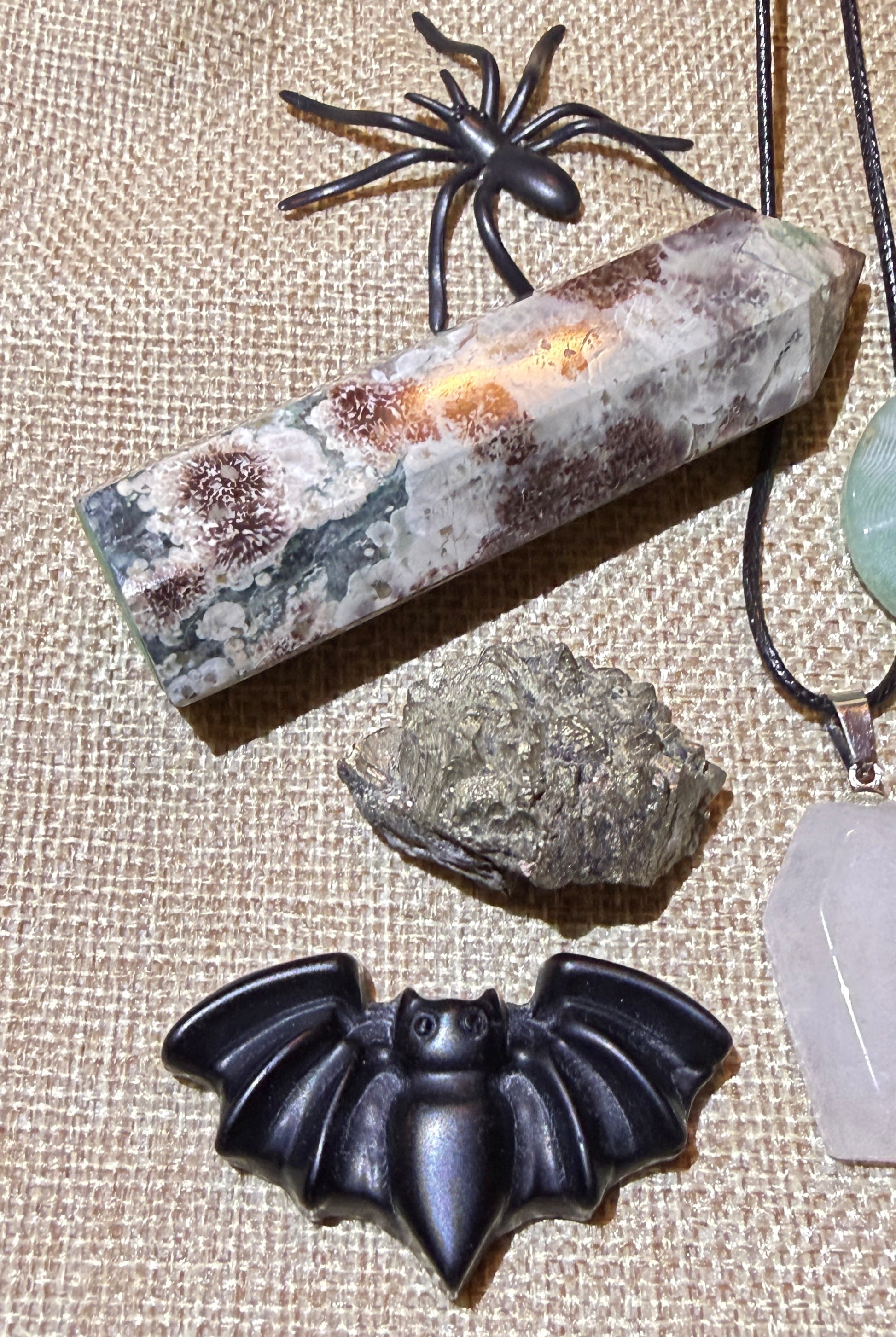 close up photo of rainforest tower, pyrite and black obsidian carving