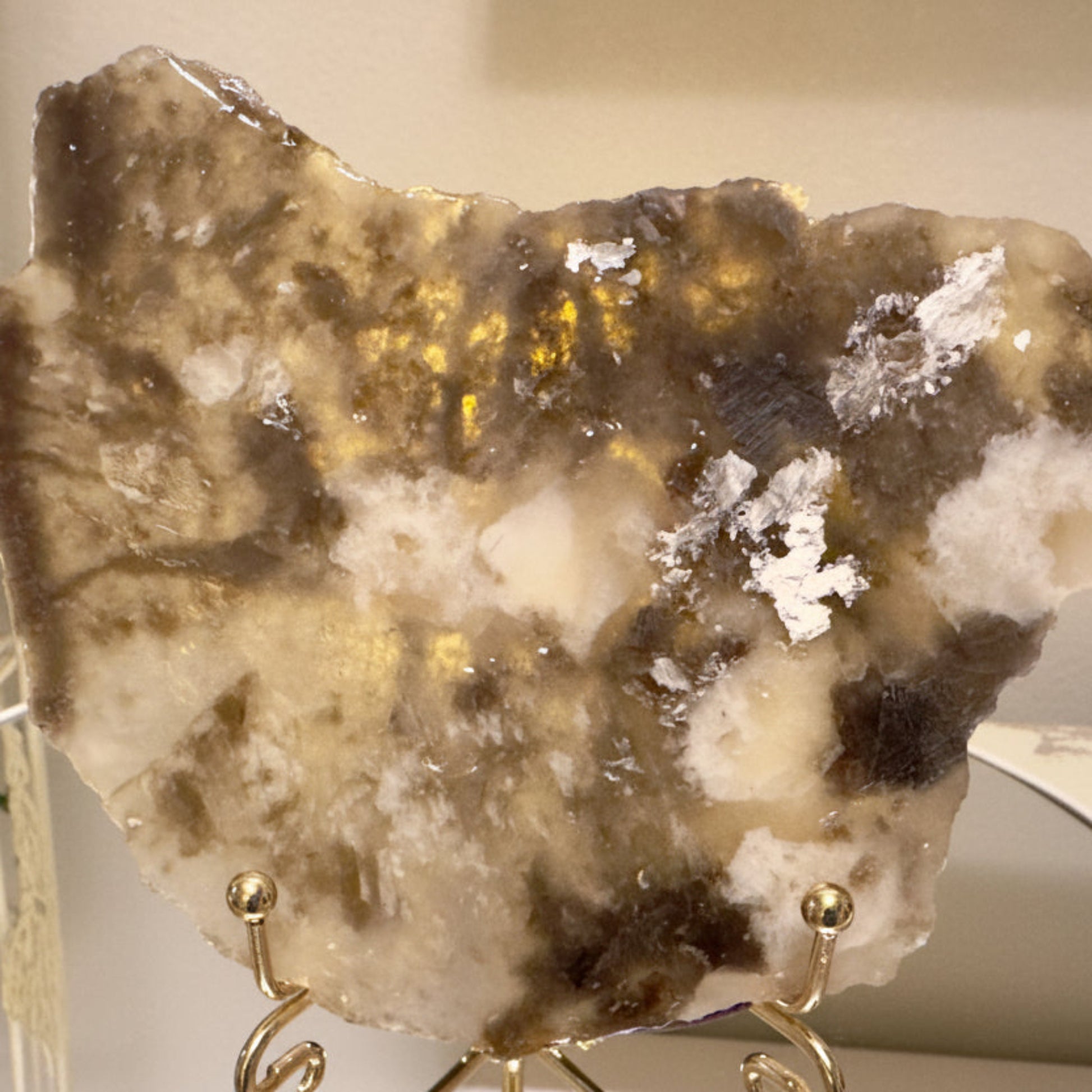 beautiful golds, tans and muscovite shimmer slab in an easel stand