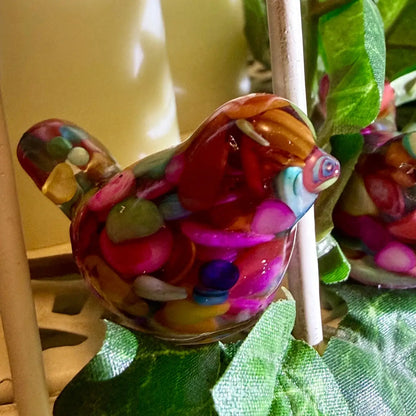 side view of organite-like bird colorful dyed agate and gold tone metal shavings, sealed in resin 