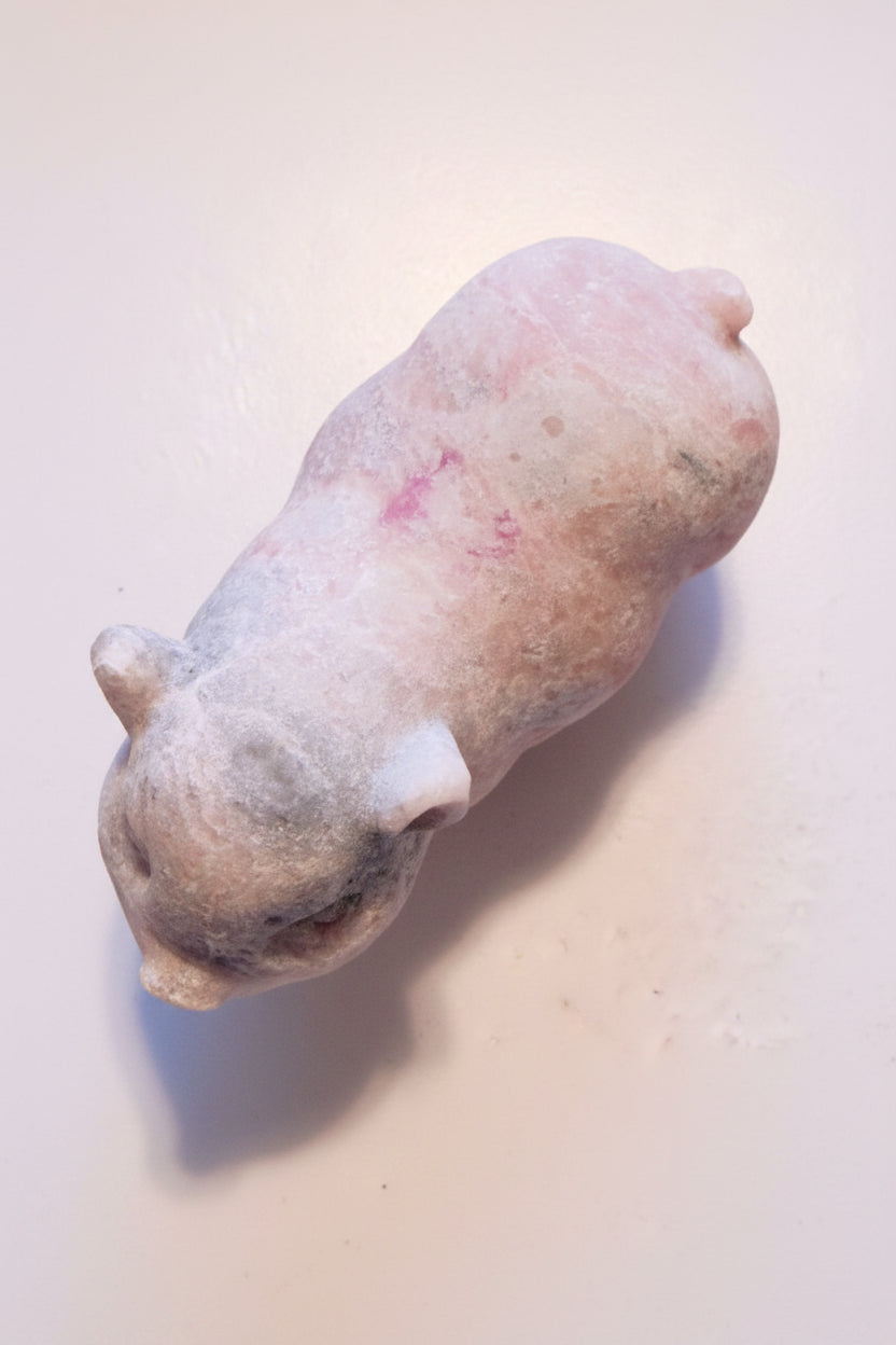 over head photo of pink calcite carved pig  colors are pink and gray