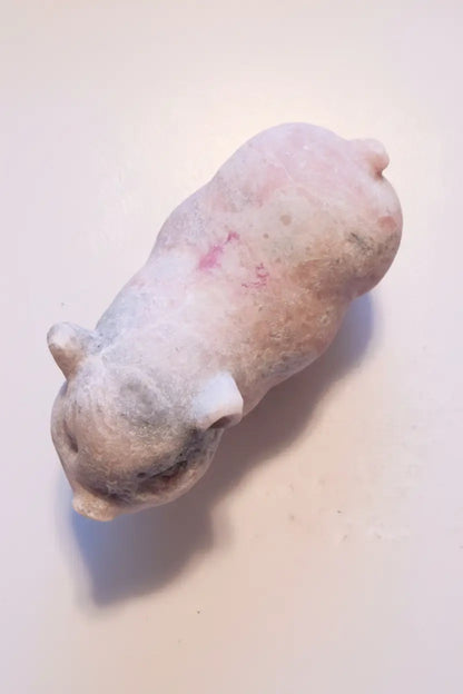 over head photo of pink calcite carved pig  colors are pink and gray